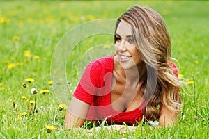 Young woman in red dress lying on grass