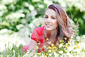 Young woman in red dress lying on grass