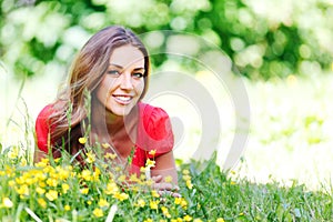 Young woman in red dress lying on grass