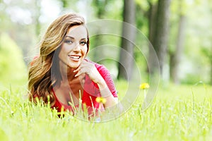 Young woman in red dress lying on grass