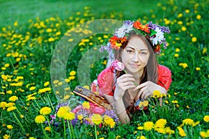 Young woman in a red dress lying on the grass in the Meadow