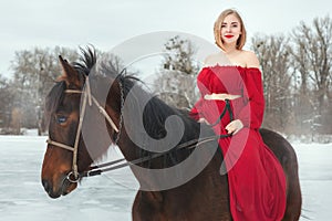 Young woman in red dress riding horse.