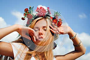 Young woman in red flower wreath with closed eyes