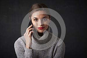 Young woman with red lipstick using her mobile phone