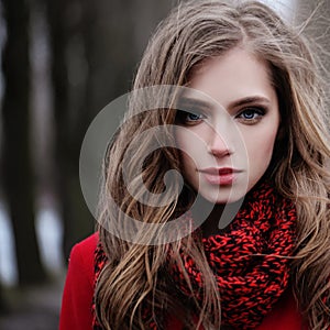 Young woman in red scarf in park. Perfect female face