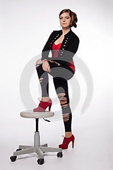 Young woman in red shirt, modern jacket, leggings with holes, re