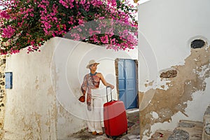 Young woman with a red suitcase in island  Santorini