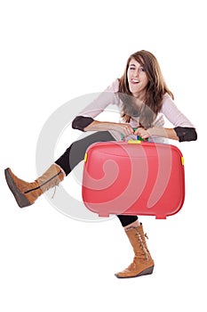 Young woman with red suitcase making funny faces