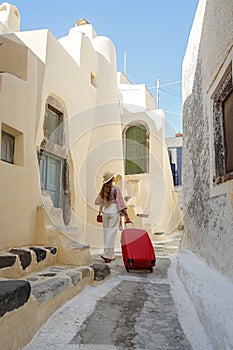 Young woman with a red suitcase travels