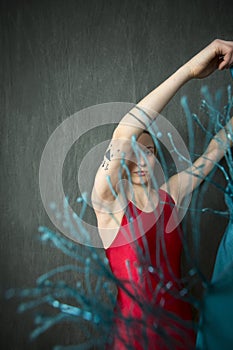 Young woman in red unitard waving a blue scarf. photo