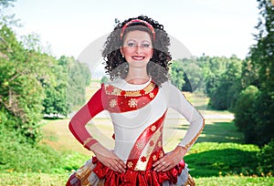 Young woman in red and white irish dance dress and wig posing