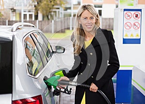 Young woman refilling car in gas station