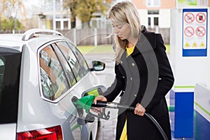 Young woman refilling petrol in gas station