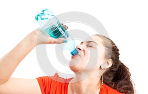 Young woman refreshing by drinking water from plastic bottle