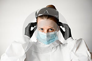 Young woman regulate medical mask with her hands