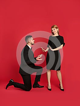 Young woman rejecting engagement ring from boyfriend on background