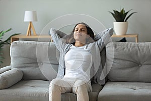 Young woman relax on comfortable sofa breathing fresh air
