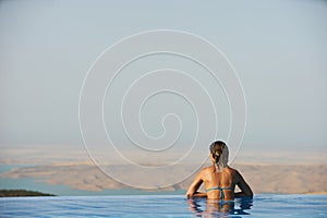 Young woman relaxaing in the swimming pool