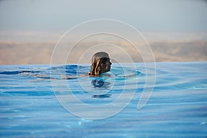 Young woman relaxaing in the swimming pool