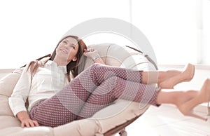 Young woman relaxes in a comfortable chair.