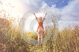 Young woman relaxing with arms raised to the sky in the middle of the nature