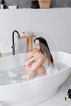 Young woman relaxing in bathtub with