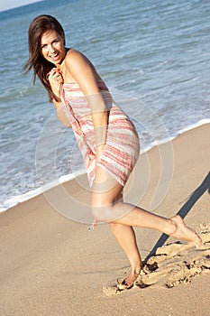 Young Woman Relaxing On Beach wearing wrap