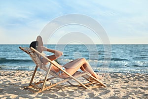 Young woman relaxing in  chair on beach