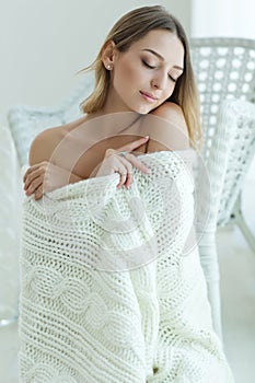 Young woman relaxing with chunky wool blanket. Relax, comfort lifestyle. Winter style.