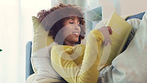 Young woman relaxing, enjoying a novel, reading a book at home. Content and smart female student studying literature and