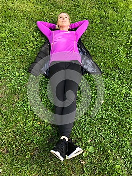 Young woman relaxing on green grass