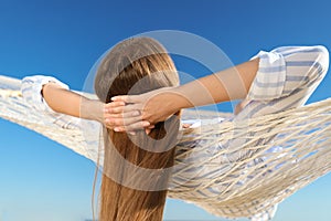 Young woman relaxing in hammock on beach