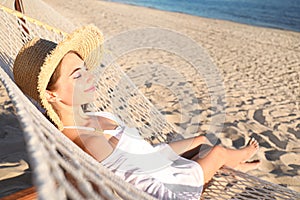 Young woman relaxing in hammock on beach