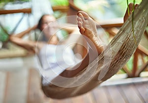 Young woman relaxing in hammock in a tropical resort. Focus on f