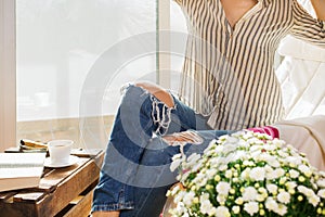 Young woman is relaxing at home, drinking tea, reading book