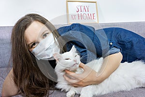 Young woman relaxing at home with pet cat. Cozy time at home. Self time and Coronavirus outbreak quarantin concept