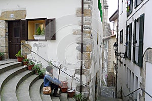 Young woman relaxing on Hondarribia old village streets during a winter morning walk, Basque Country, Spain
