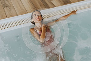 Young woman relaxing in the indoor swimming pool
