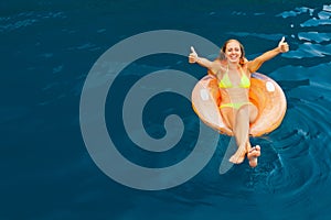 Young woman relaxing on inflatable floating ring