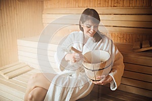 Young woman relaxing inside spa sauna room.Enjoying relaxing vacation day doing body treatment in luxury resort hotel.Beauty