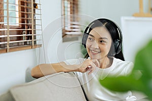 young woman relaxing and listening to the music on the phone on the couch