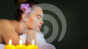 Young woman relaxing during massage therapy at luxury beauty spa