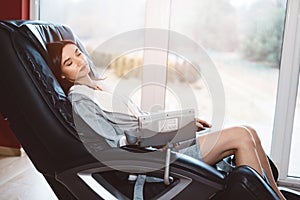 Young woman relaxing on the massaging chair