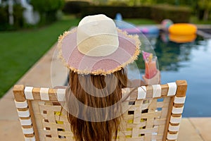 Young woman relaxing near swimming pool on a sunny day