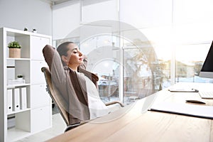 Young woman relaxing in office chair at workplace