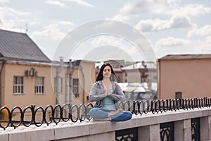Young woman in a relaxing pose on the parapet