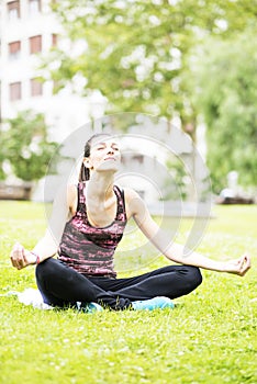 Young Woman Relaxing and Practicing Yoga in the Park.