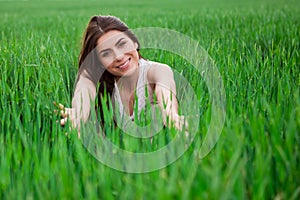 Young woman relaxing and smiling in fresh green fi