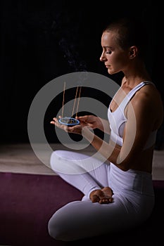 Young woman relaxing with smoking aromatic sticks. aromatherapy, meditation