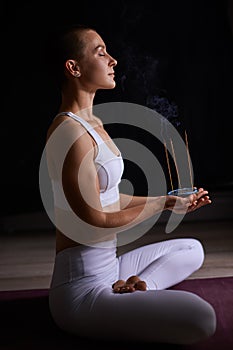 Young woman relaxing with smoking aromatic sticks. aromatherapy, meditation